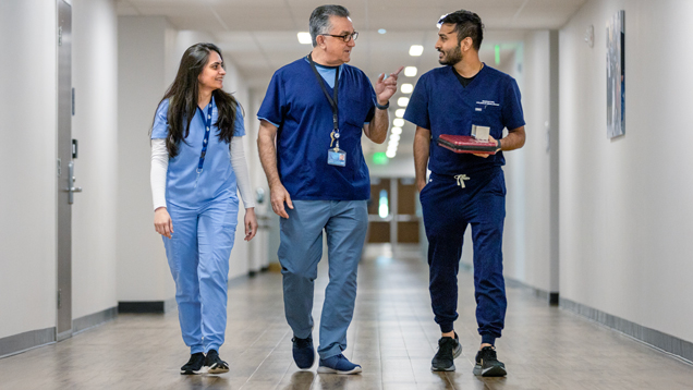 Professor and students walking around Tampa Bay hallway speaking