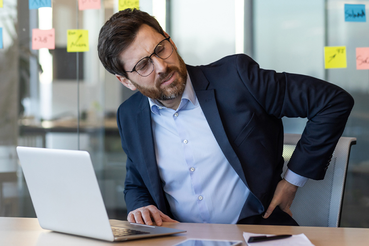 Man holding his back in pain at the office