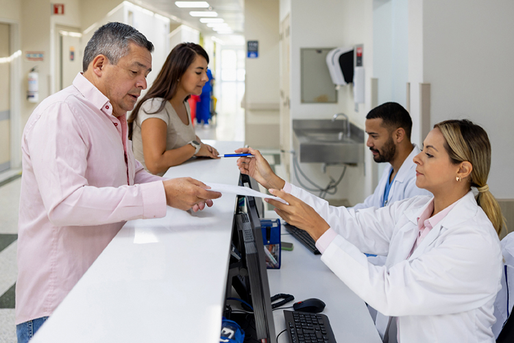 Patients signing documents at a registration desk