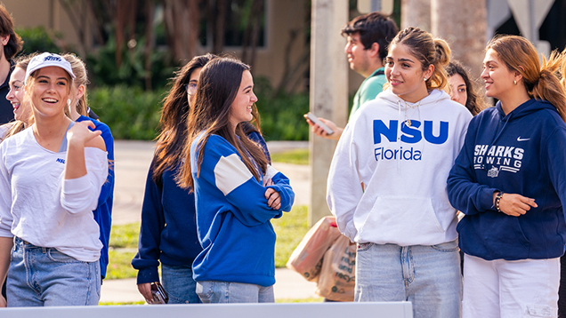 Group of NSU students talking outside of campus