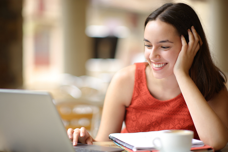 Student smiling while using her laptop