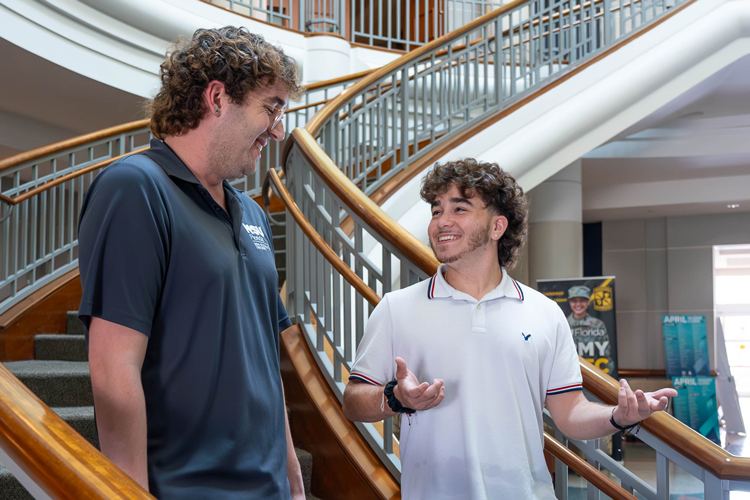 NSU students speaking on stairs