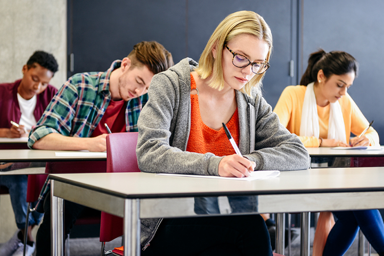 Group of students taking an exam in class