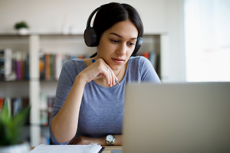 Woman using a laptop and headphones